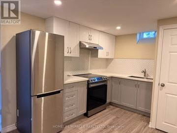 Brampton (Heart Lake West) apartment for rent - A kitchen with a stainless steel refrigerator and white cabinets.