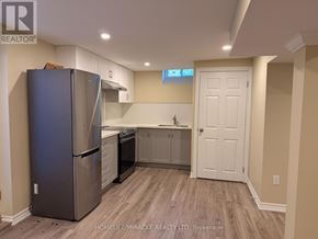 Brampton (Heart Lake West) apartment for rent - A kitchen with a refrigerator, cabinets, and a door.