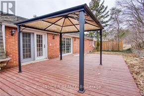 Waterloo apartment for rent - A wooden deck with a black pergola attached to a brick house.