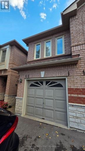 Mississauga (East Credit) townhouse for rent - A house with a grey garage door and a brick wall.