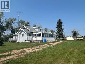 Rural Kneehill County apartment for rent - A house with a blue barrel in front of it.