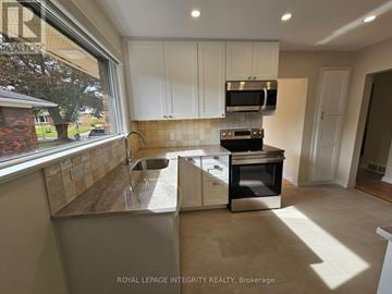 Ottawa apartment for rent - A kitchen with white cabinets and a black oven.