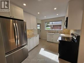 Ottawa apartment for rent - A kitchen with a stainless steel refrigerator and white cabinets.