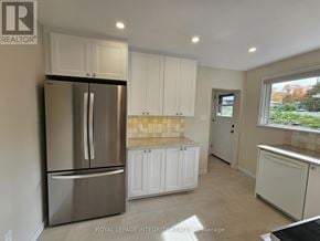 Ottawa apartment for rent - A kitchen with white cabinets and a stainless steel refrigerator.