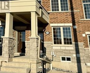Pickering townhouse for rent - A house with a stone pillar and a brown door.