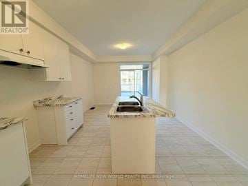 Pickering townhouse for rent - A kitchen with white cabinets and a marble island.