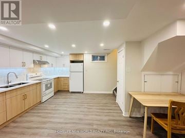 Markham (Raymerville) apartment for rent - A kitchen with wooden cabinets and a white fridge.