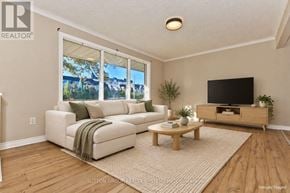 St. Catharines (Glendale/Glenridge) apartment for rent - A living room with a white couch, a wooden coffee table, and a flat screen TV.