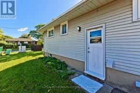 St. Catharines (Glendale/Glenridge) apartment for rent - A house with a white door and a brokerage sign in the corner.