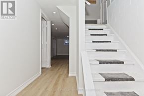 St. Catharines (Glendale/Glenridge) apartment for rent - A hallway with a staircase and a doorway leading to another room.