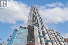 Kitchener condo for rent - A tall building with a glass facade and a sign that reads "Frederick HomeLife Miracle Realty LTD Brokerage.".