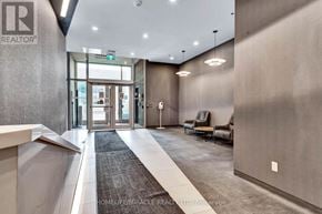 Kitchener condo for rent - A hallway with a carpeted area in front of a glass door.