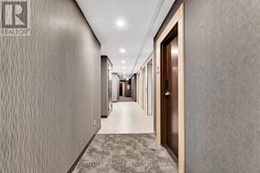 Kitchener condo for rent - A hallway with a carpeted floor and doors on both sides.