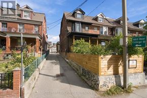 Toronto (Palmerston-Little Italy) duplex for rent - A residential street with houses on both sides and a street sign for 660 Rear College St.