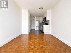 Toronto (Church-Yonge Corridor) condo for rent - A kitchen with white cabinets and a wooden floor.