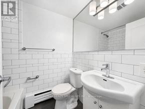 Toronto (Church-Yonge Corridor) condo for rent - A white bathroom with a toilet, sink, and mirror.