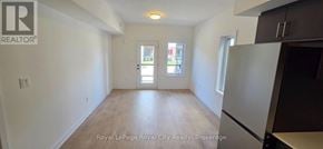 Guelph (Clairfields/Hanlon Business Park) townhouse for rent - A white room with a wooden floor and a door leading to a balcony.
