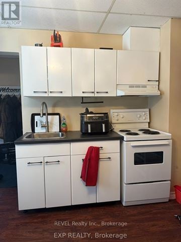 St. Catharines (Downtown) fourplex for rent - A kitchen with white cabinets and appliances.