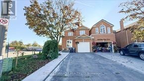 Mississauga (East Credit) townhouse for rent - A house with a garage and a tree in front of it.