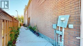 Mississauga (East Credit) townhouse for rent - A narrow alley with a brick wall and a wooden fence on the left.
