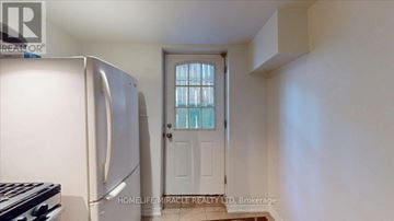 Mississauga (East Credit) townhouse for rent - A white refrigerator sits in a kitchen next to a door.