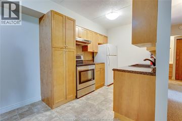 Windsor condo for rent - A kitchen with wooden cabinets and appliances.