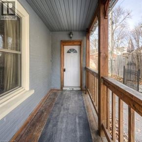 Kitchener apartment for rent - A wooden door is at the end of a porch.