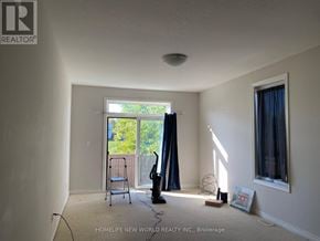 St. Catharines (Oakdale) townhouse for rent - A room with a vacuum cleaner and a picture frame on the floor.
