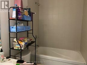 St. Catharines (Oakdale) townhouse for rent - A bathroom with a tub, toilet, and shelves with bathroom supplies.