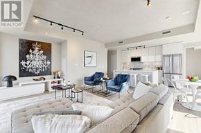 Toronto (Moss Park) condo for rent - A living room with a grey couch and a chandelier.