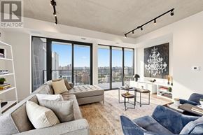 Toronto (Moss Park) condo for rent - A living room with a couch, a chair, and a table with a plant on it.