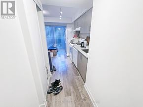 Toronto (Kensington-Chinatown) condo for rent - A pair of black shoes are on the floor of a kitchen.