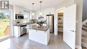 Casselman townhouse for rent - A modern kitchen with white cabinets and a large island.