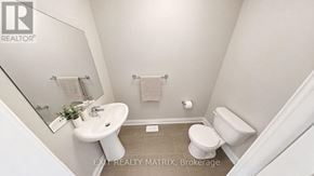 Casselman townhouse for rent - A bathroom with a toilet, sink, and mirror.
