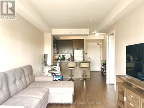 Toronto (Downsview-Roding-Cfb) condo for rent - A well-lit, modern living room with a grey sofa and a bar area.