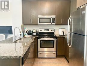 Toronto (Downsview-Roding-Cfb) condo for rent - A kitchen with a stove top oven and a refrigerator.