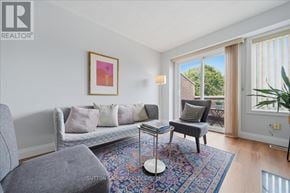 Mississauga (Hurontario) townhouse for rent - A living room with a grey couch, a small table, and a painting on the wall.