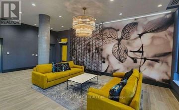 Brampton (Northwest Brampton) condo for rent - A living room with a yellow sofa and a white coffee table.