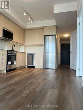 Milton (Tm Timberlea) condo for rent - A kitchen with wooden floors and a black refrigerator.