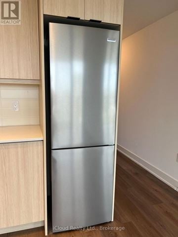 Milton (Tm Timberlea) condo for rent - A stainless steel refrigerator in a kitchen with wooden cabinets.