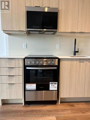 Milton (Tm Timberlea) condo for rent - A modern kitchen with a stainless steel oven and microwave above it.