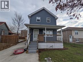 Windsor apartment for rent - A blue house with a porch and a red frisbee on the sidewalk.