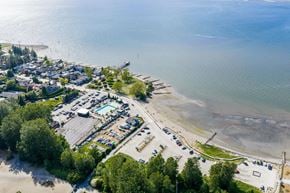 Surrey apartment for rent - A beachside area with a parking lot and a body of water.