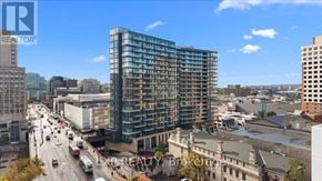 Ottawa condo for rent - A patio with a fire pit and chairs is surrounded by a wall and a building.