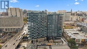 Ottawa condo for rent - A tall building with many windows is in the middle of a city.
