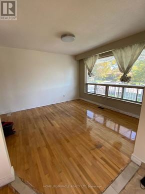 Mississauga (Malton) apartment for rent - A room with wooden flooring and a window with curtains.