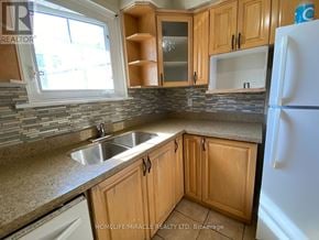 Mississauga (Malton) apartment for rent - A kitchen with wooden cabinets and a white refrigerator.