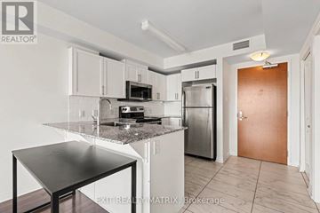 Ottawa condo for rent - A kitchen with a table and a refrigerator.