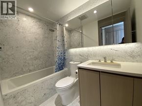 Burnaby apartment for rent - A bathroom with a marble wall and a white toilet.