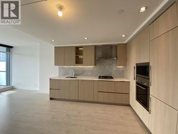 Burnaby apartment for rent - A modern kitchen with wooden cabinets and a marble backsplash.